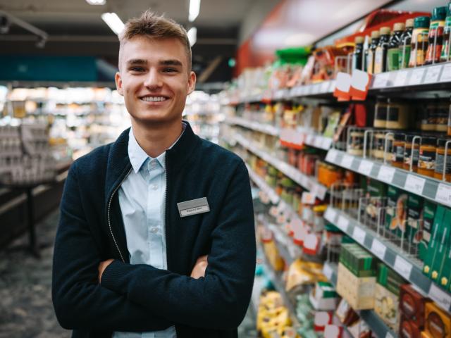 Jeune vendeur devant un rayon